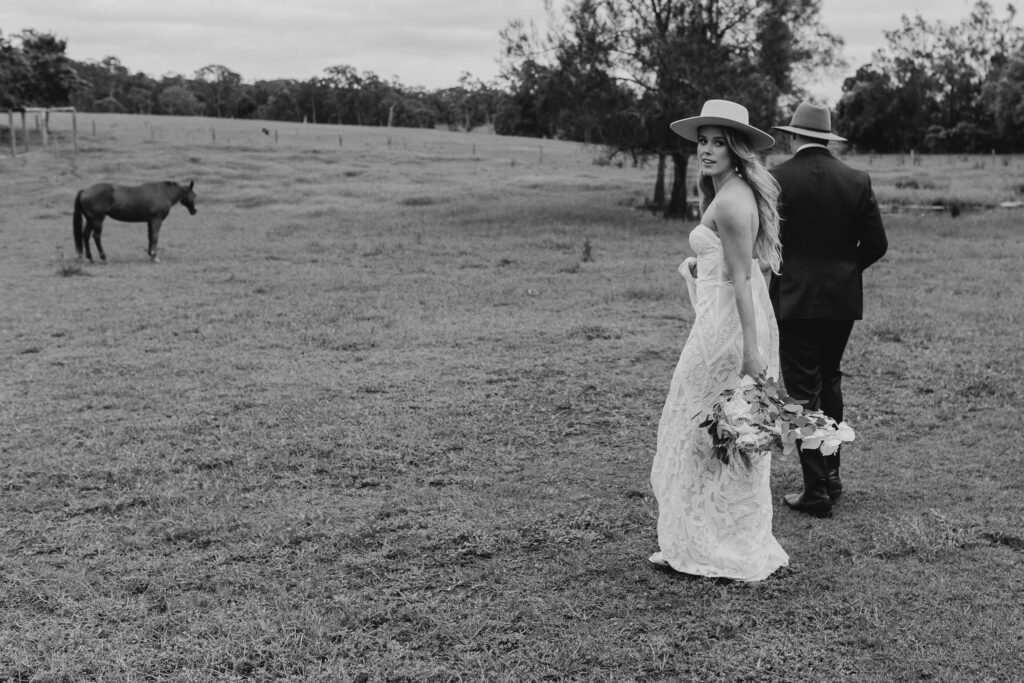 bride and groom walking in paddock at sunshine coast hinterland wedding