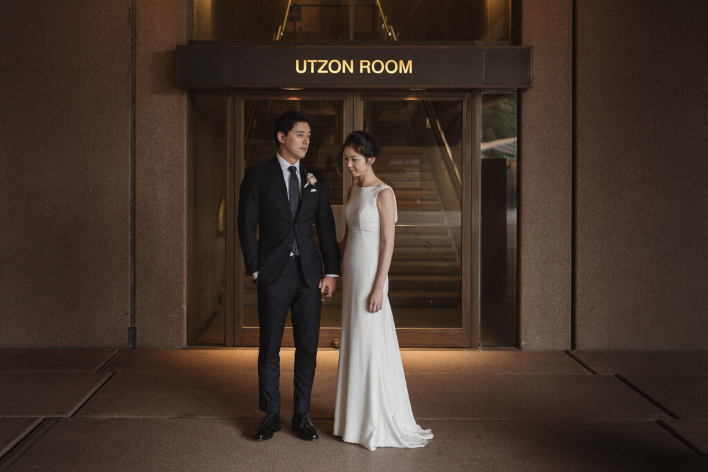 groom and bride posing at utzon room wedding