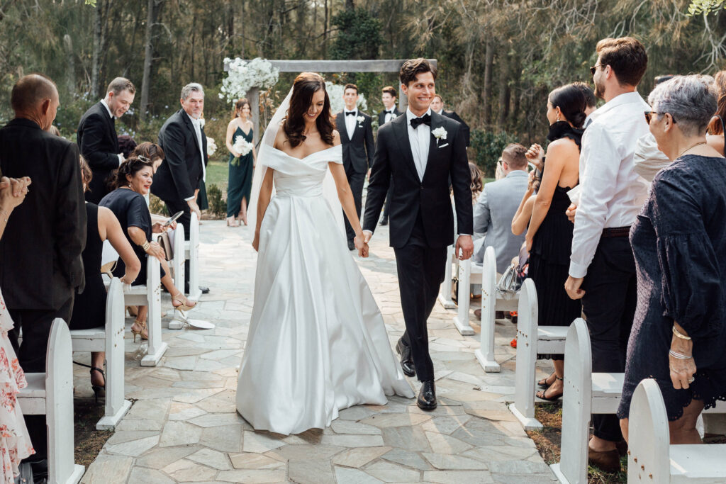 bride and groom walking down aisle at byron bay wedding