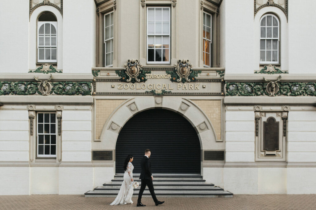 bride and groom walking under toronga zoo park sign