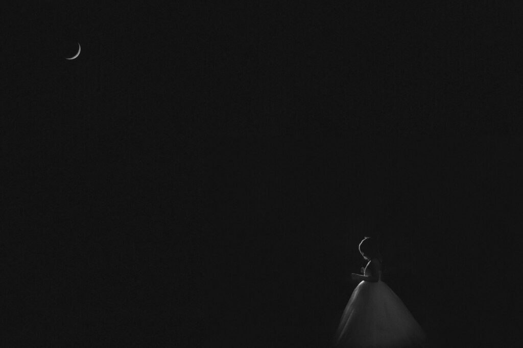 young girl standing under the moon at byron bay hinterland