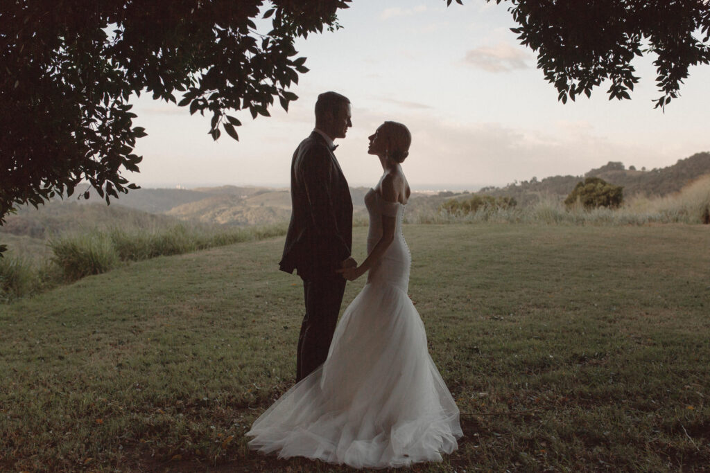 groom and bride holding hands under a tree at summergrove estate wedding