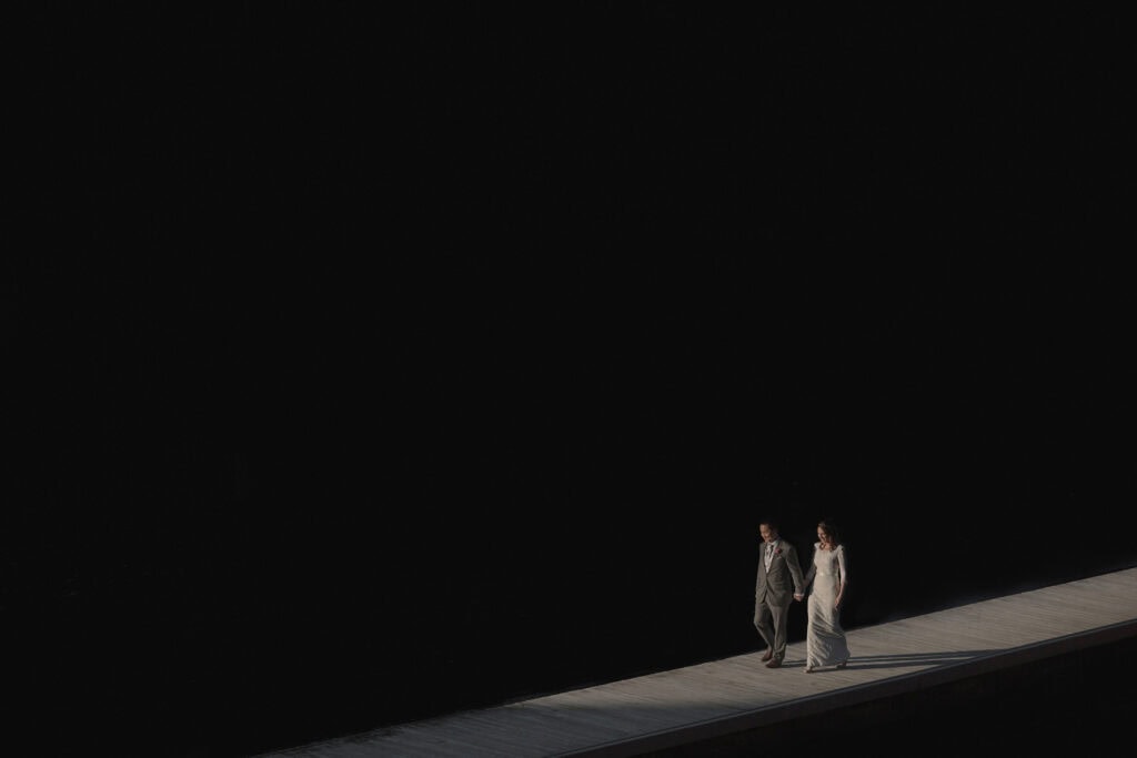 Sydney wedding photography - couple walking hand in hand on a bridge at night.