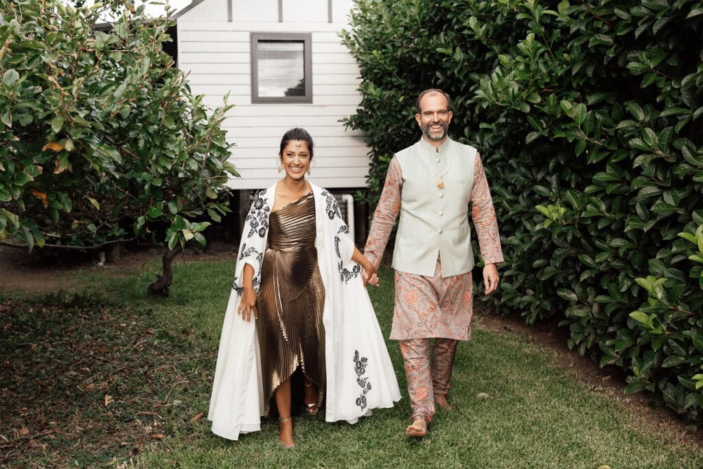 Sydney wedding photography - happy couple walking outdoors, smiling, surrounded by greenery.
